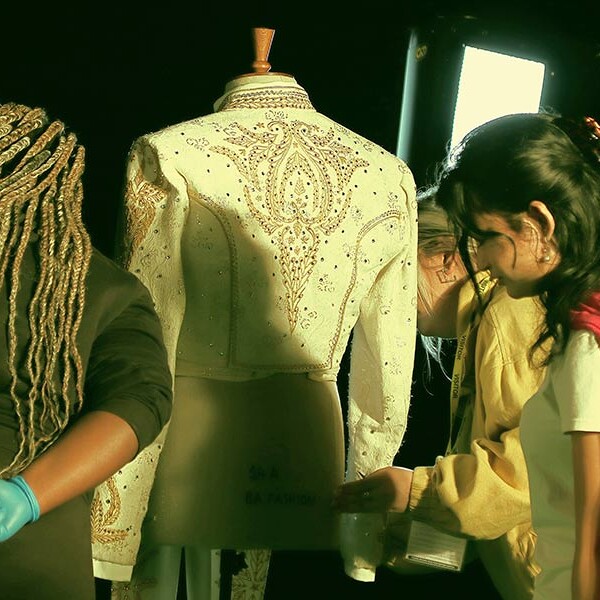 Students placing outfit onto mannequin