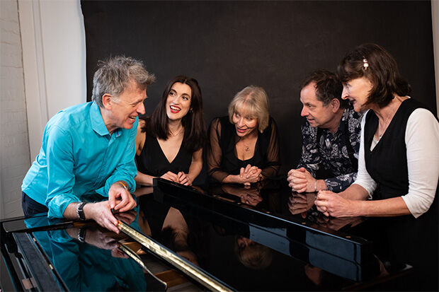 The members of the improv opera ensemble Impropera around a piano