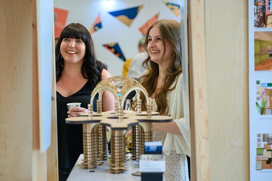 Student and lecturer behind wooden model of arched structure