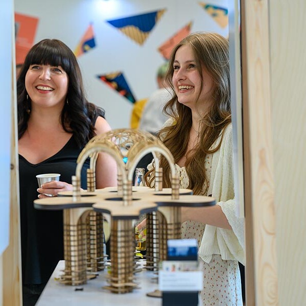 Student and lecturer behind wooden model of arched structure