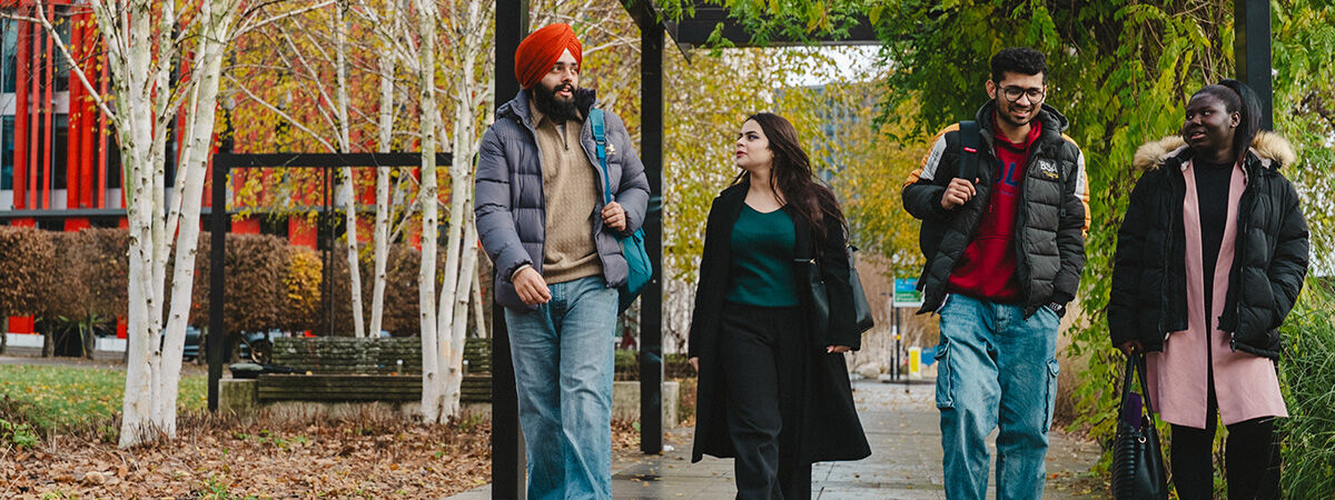 Four international students walking through the trees