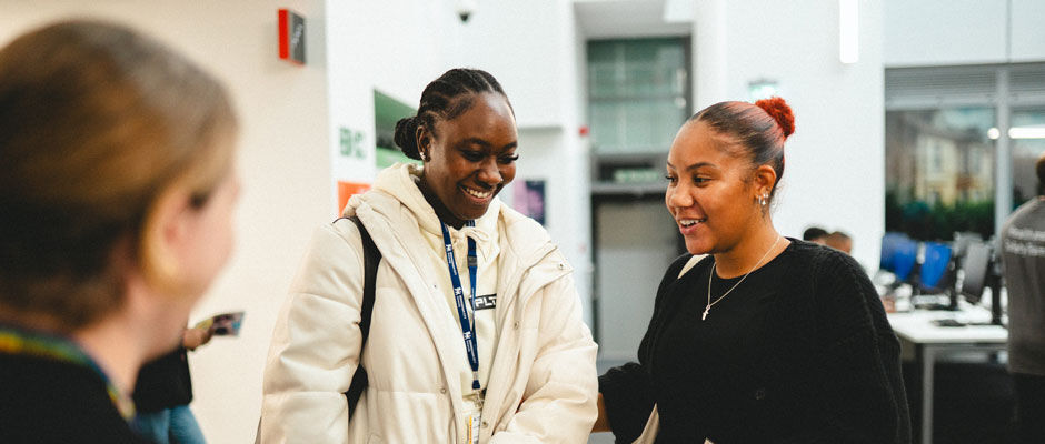 Two students talk to a member of staff during the Welcome Fair