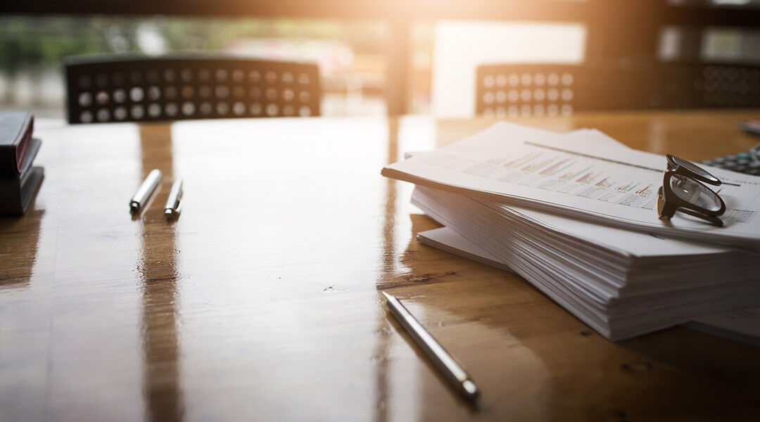 Stack of documents with glasses on top