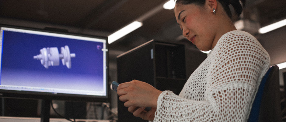 A student smiles at her phone