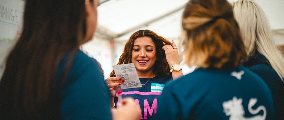 A student wearing a name tag talks to a group of students during welcome week