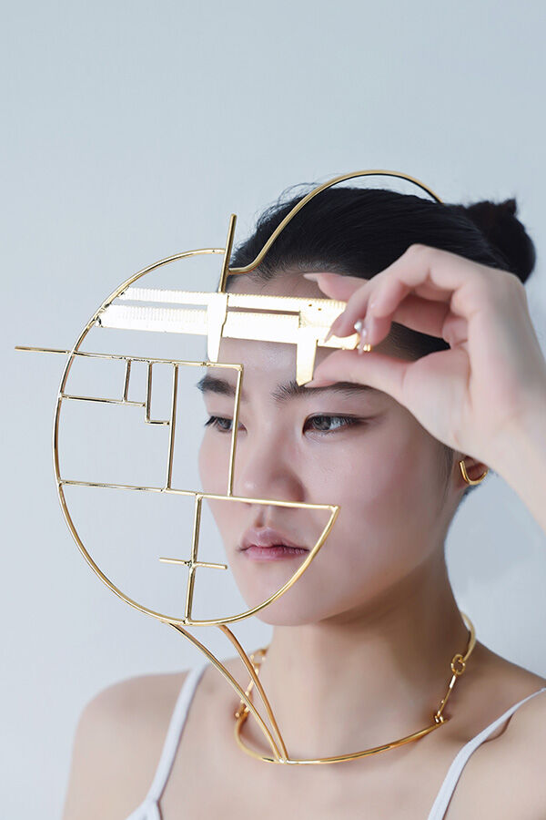 Jewellery and Objects student work -- student wearing gold face jewellery