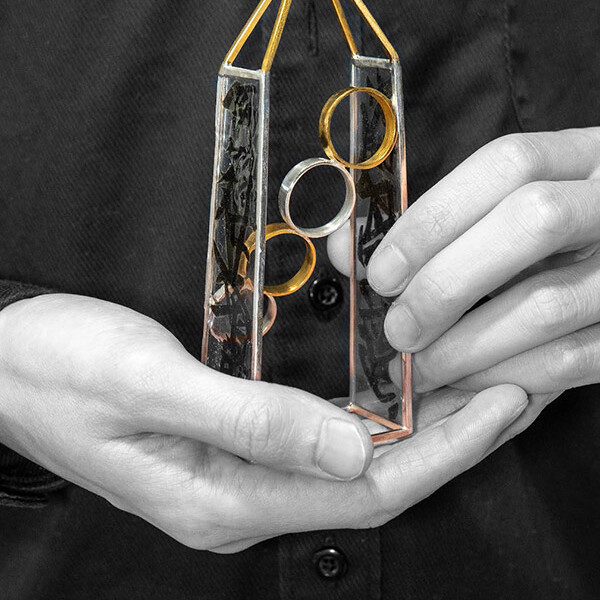 A student holding a collection of ring housed in a metal box