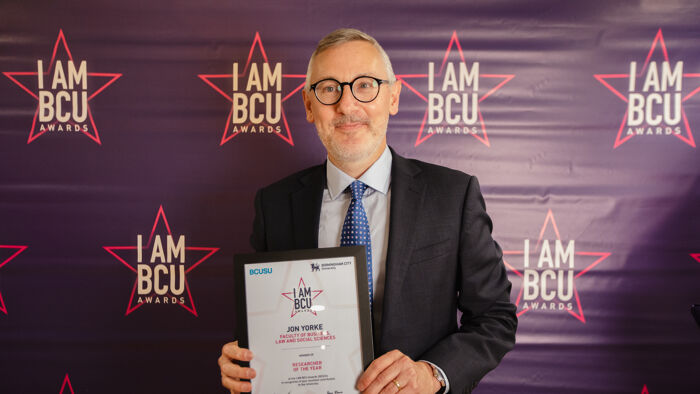 Professor Jon Yorke holding IAMBCU award