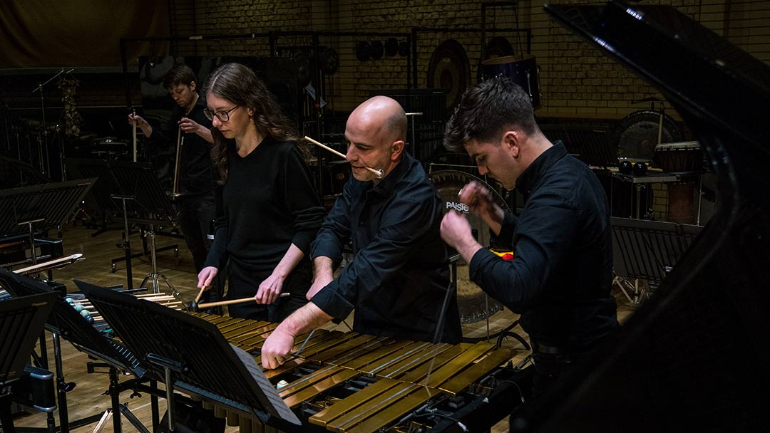 Students performing using percussion instruments