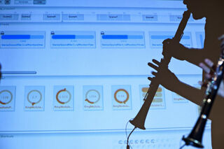 Silhouette of clarinettist against computer projection