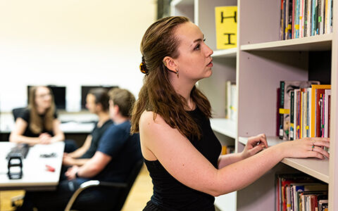 A person browsing through books in a library