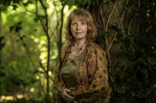 Liz Dilnot Johnson stood next to a tree in a forest