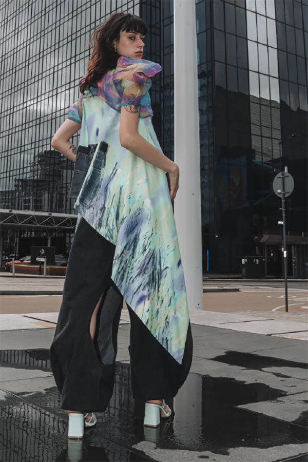 Model in coloured dress in front of skyscraper