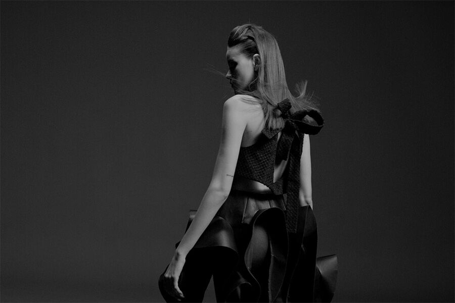 A black and white photo of a woman in a dress.