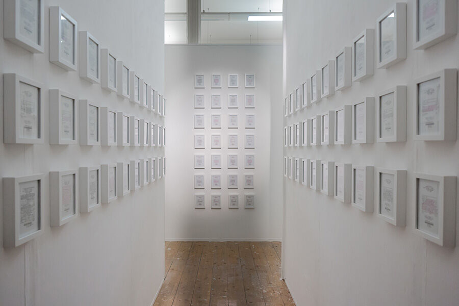 White wall corridor with lots of small white photo frames 