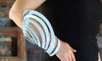 A blue piece of jewellery worn on a person's arm