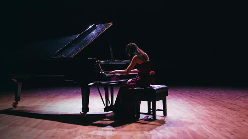 Music student playing grand piano