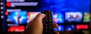 Netflix Entrepreneur Article 1200x450 - Remote in front of a TV screen showing Netflix