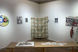 art gallery with person hiding behind blanket