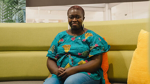 Nsikan sat on a green sofa