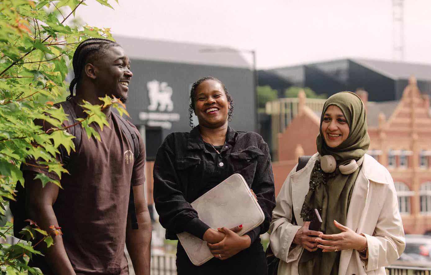 Three students laughing outside Steam House