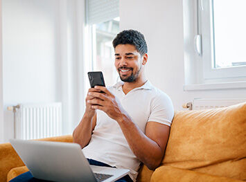 A man sitting on a sofa on his mobile phone