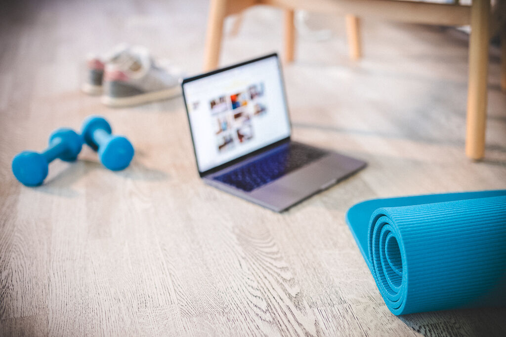 A laptop and exercise equipment ready for an online workout 