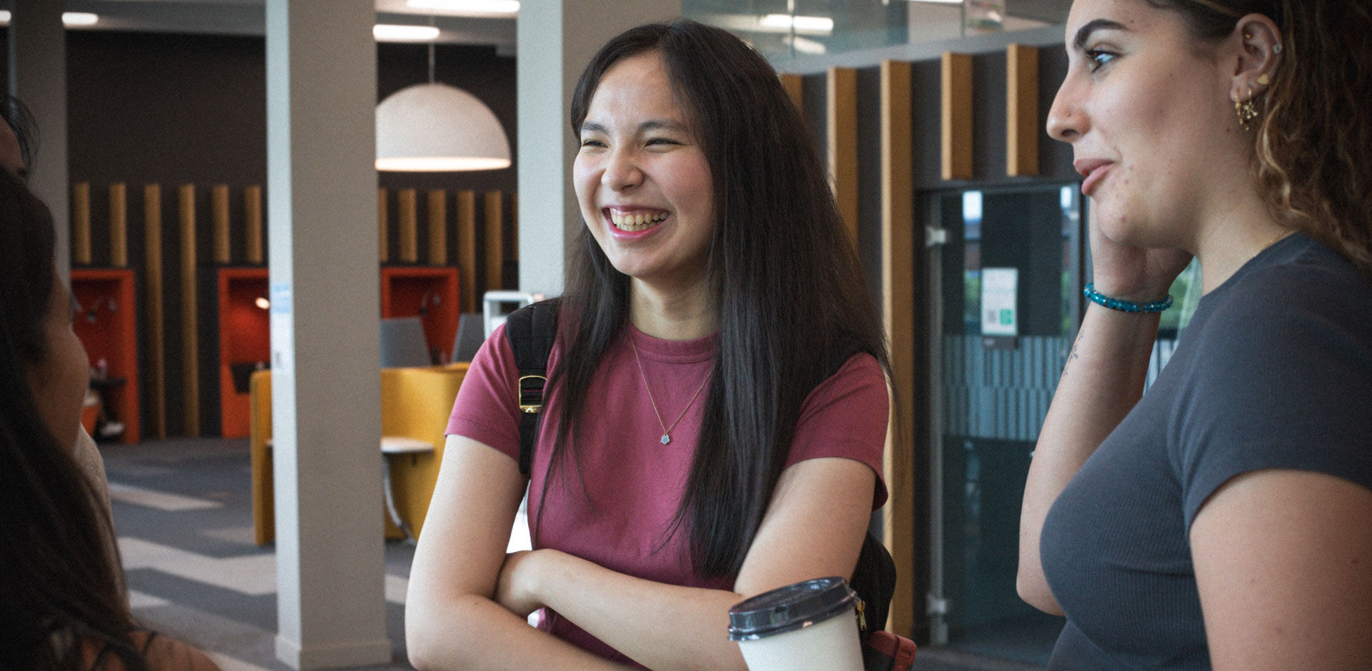 three students talk and laugh in Curzon study area