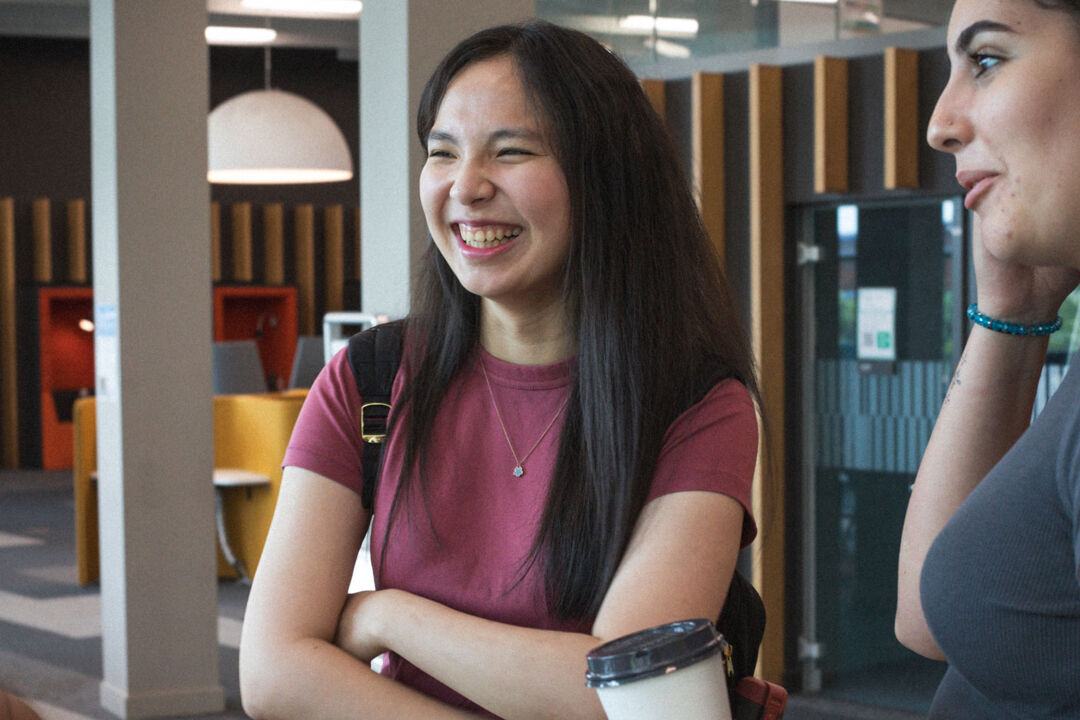three students talk and laugh in Curzon study area
