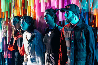 Singing students performing against colourful background