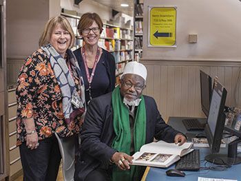 Professor Peligah views his thesis with Birmingham School of Art library staff
