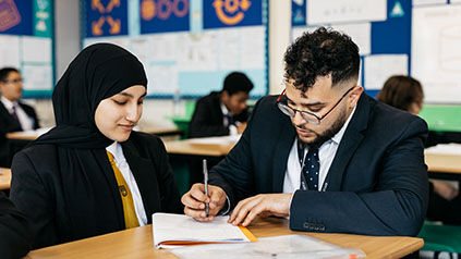 teacher and student talking at a desk
