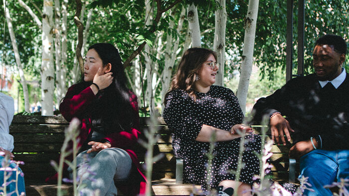 Four postgraduate students sat together outside