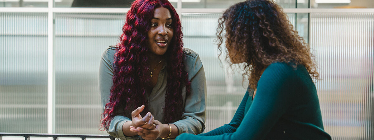 Postgraduate Students chatting on a balcony with curly red hair