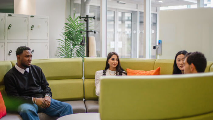 PhD students chatting on green sofa