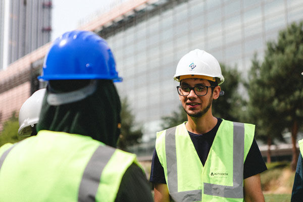 A built environment student wearing a hard hat and high vis