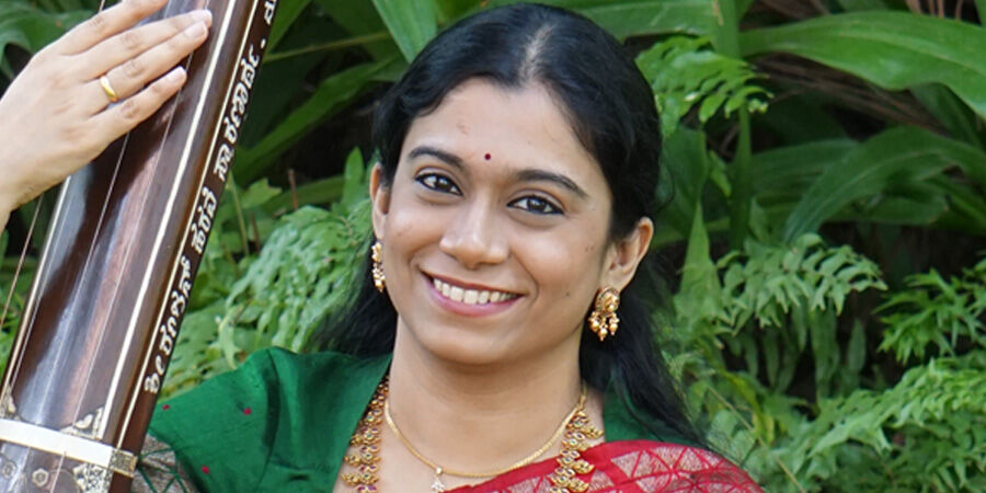 Dr Radhika Balakrishnan sat in front of a tree.