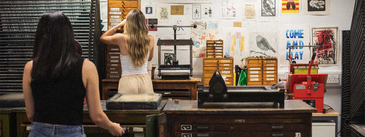 Two students in the print room, using the facilities