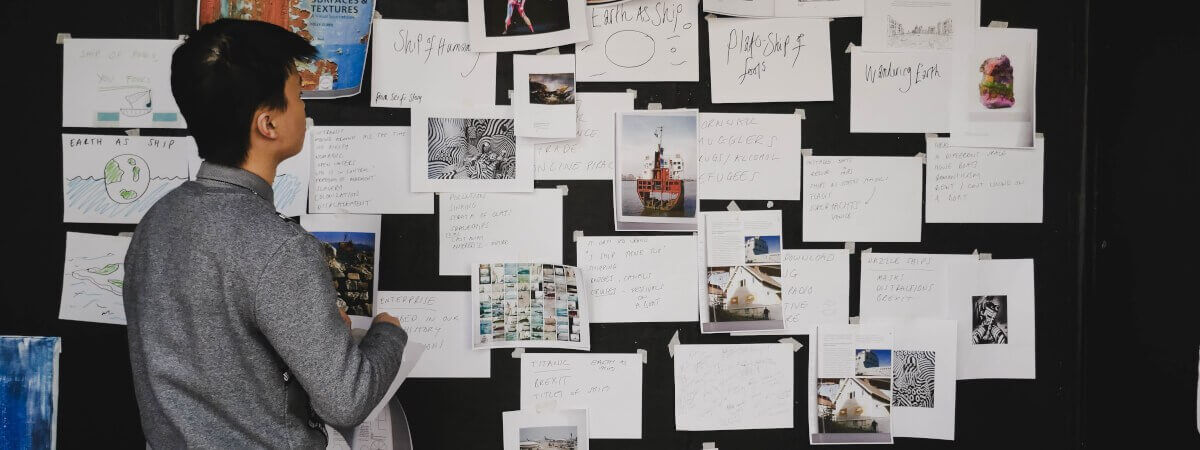 A wall with a collection of papers showing text and images