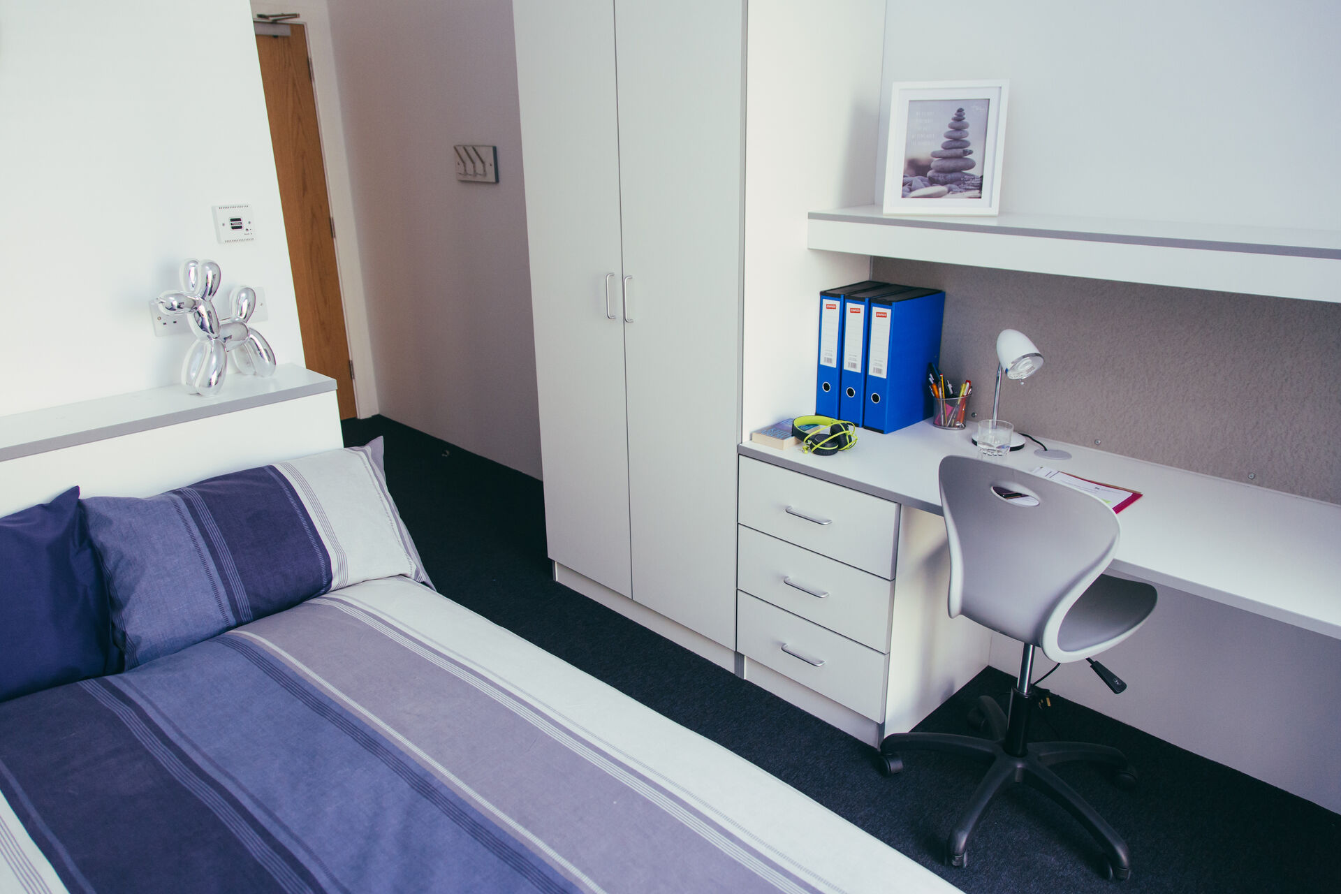 A bed, desk and wardrobe in a bedroom