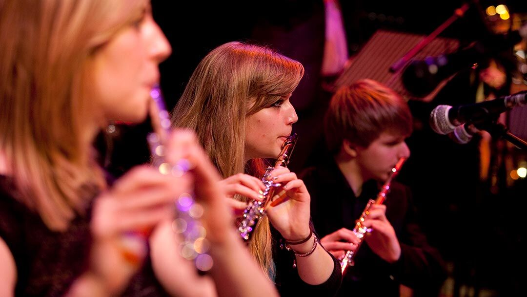 Students playing woodwind instruments in orchestra