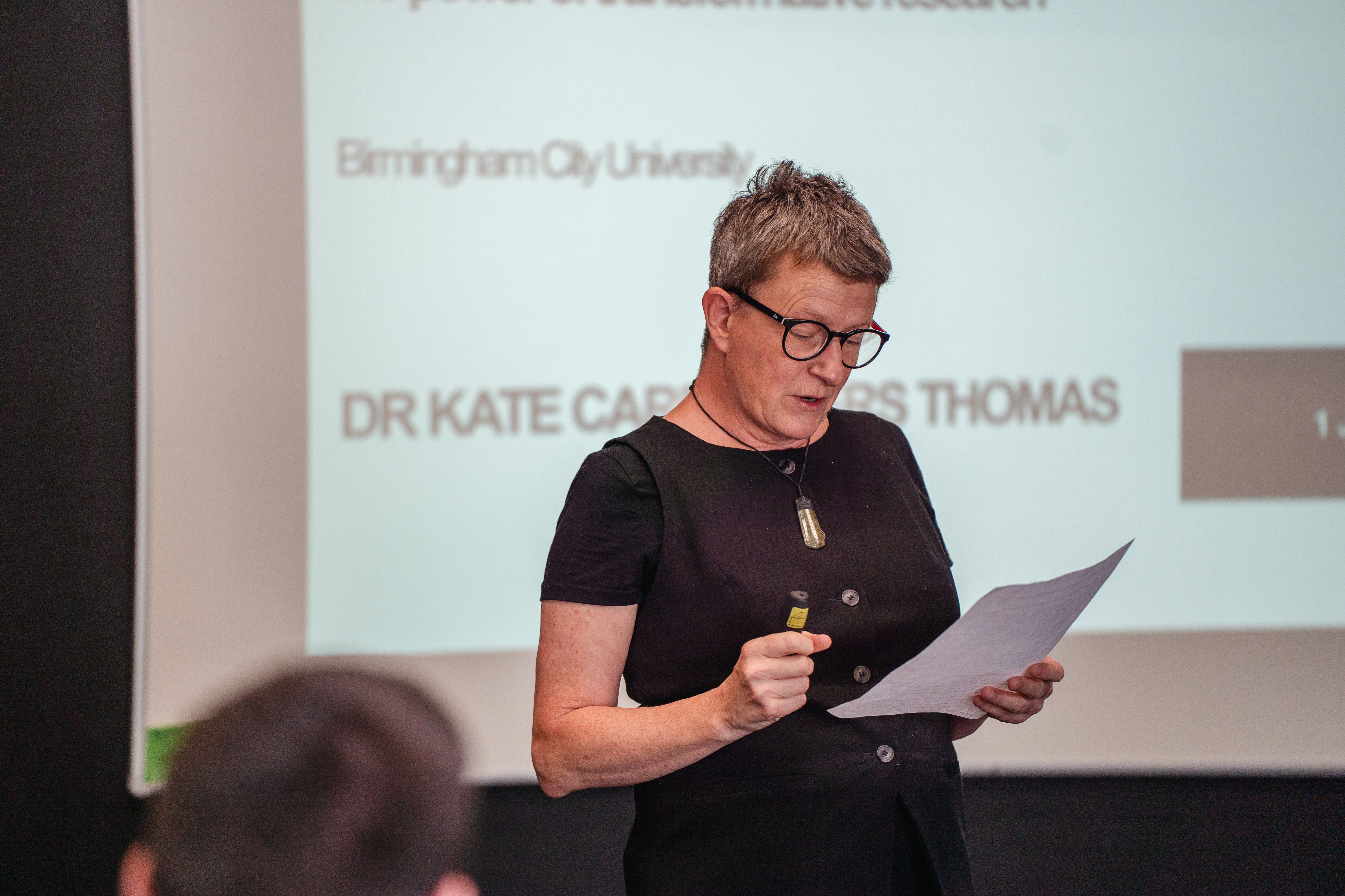 Dr Kate Thomas Reading a Piece of Paper