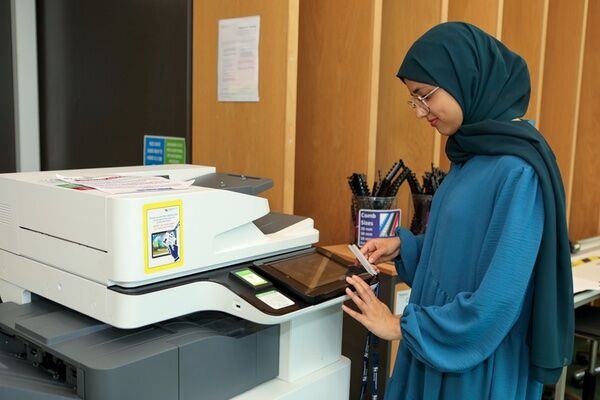 A young female student is using a printer