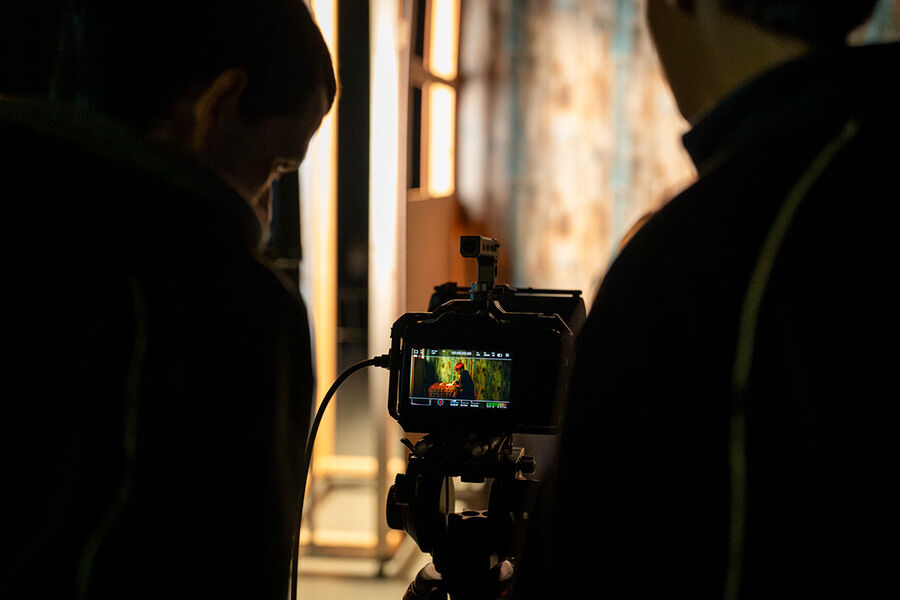 Two students looking at screen behind camera