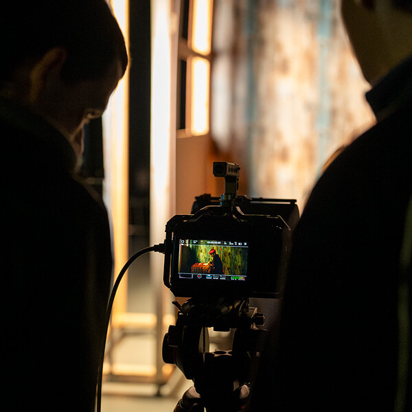 Two students looking at screen behind camera