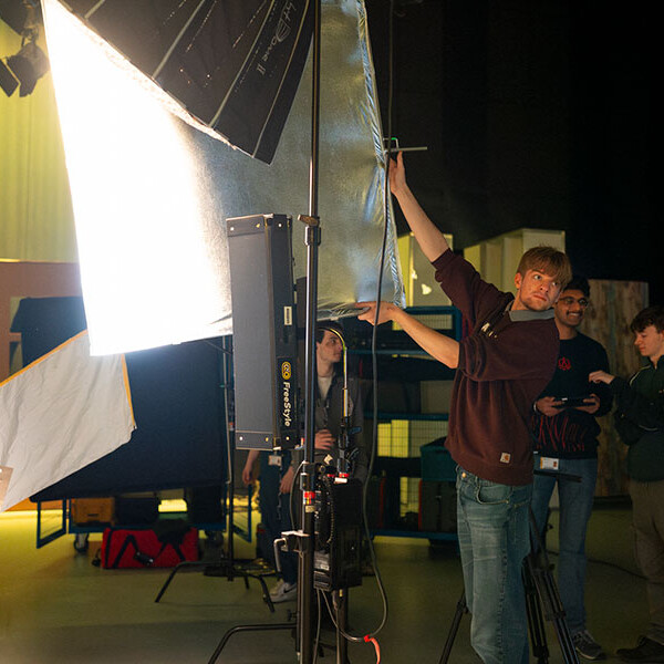 Students setting up lights in studio