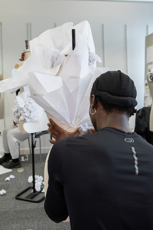 Student styling white garment on mannequin