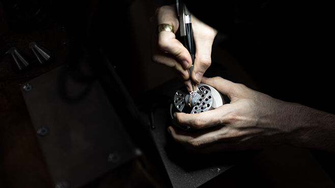Close up of student's hands working on jewellery mechanism 