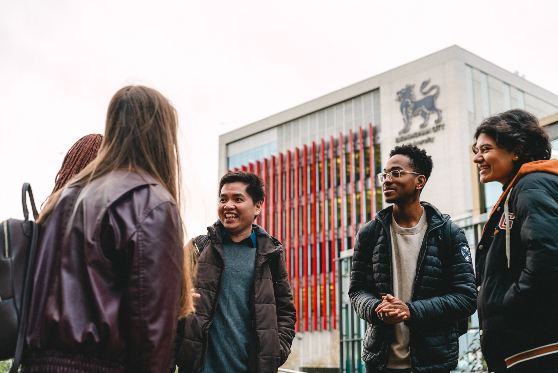 A group of 5 students talking in front of BCU's Curzon Building