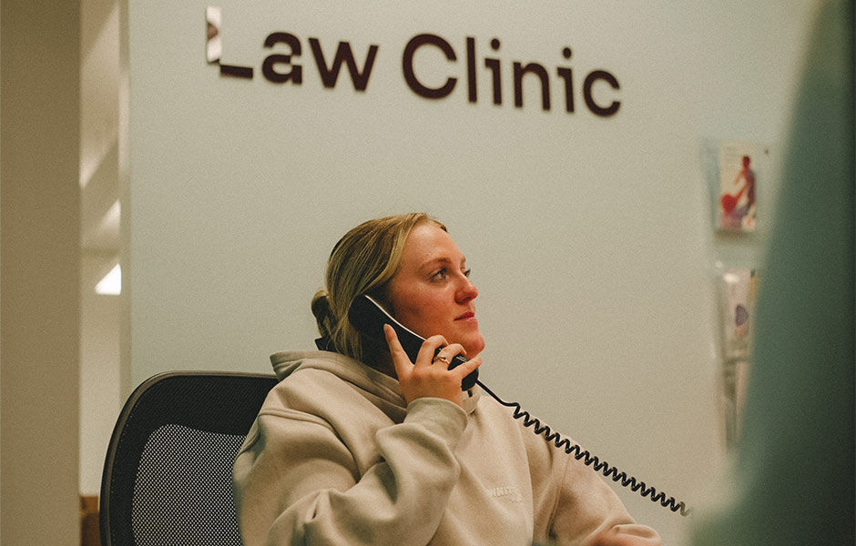 A student using the phone in the Law Clinic